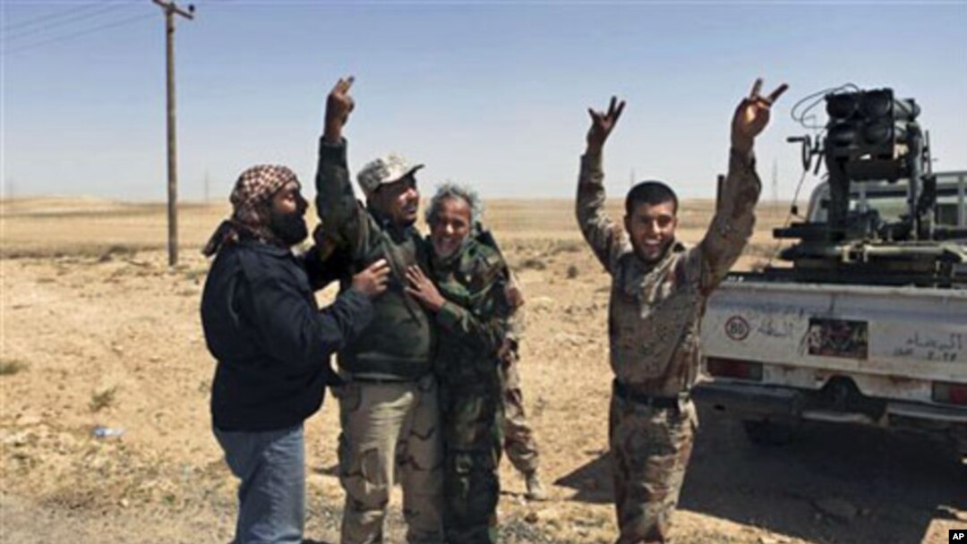 Libyan rebels celebrate as their shell hit its target outside Brega, Libya. Libyan government forces unleashed a withering bombardment of the rebels outside a key oil town pushing them back, even as the regime said Moammar Gadhafi might consider some refo