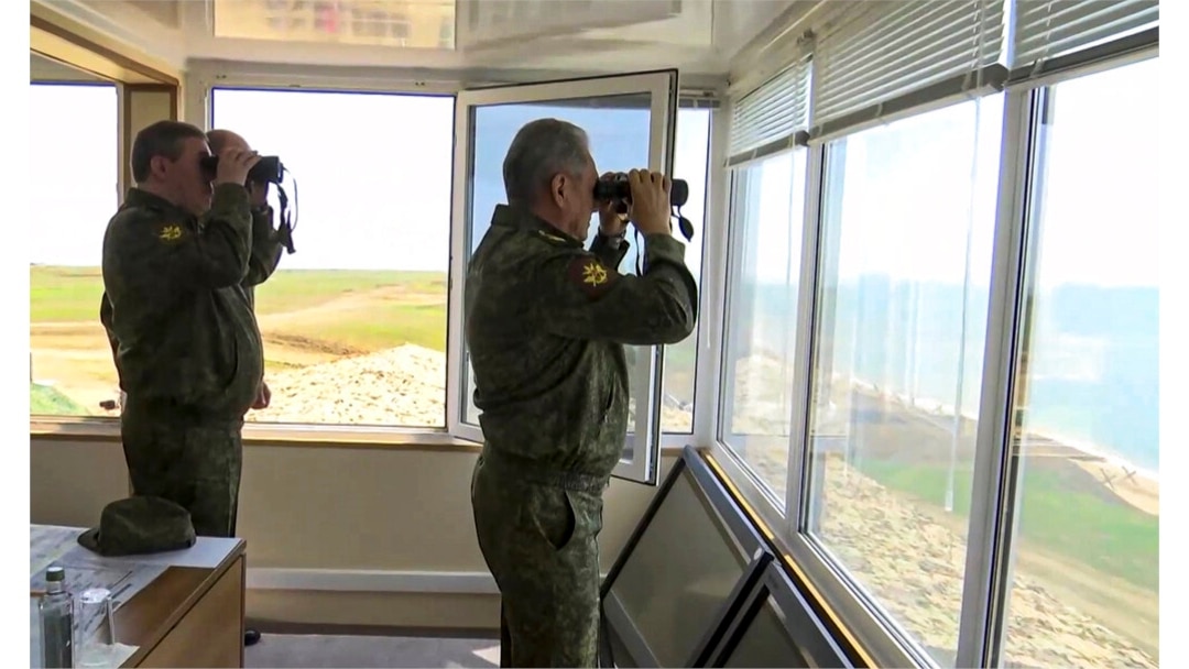FILE - Russian Defense Minister Sergei Shoigu, center, and General Staff Valery Gerasimov watch drills in Crimea, in this handout photo taken from a video released April 22, 2021, by Russian Defense Ministry Press Service.