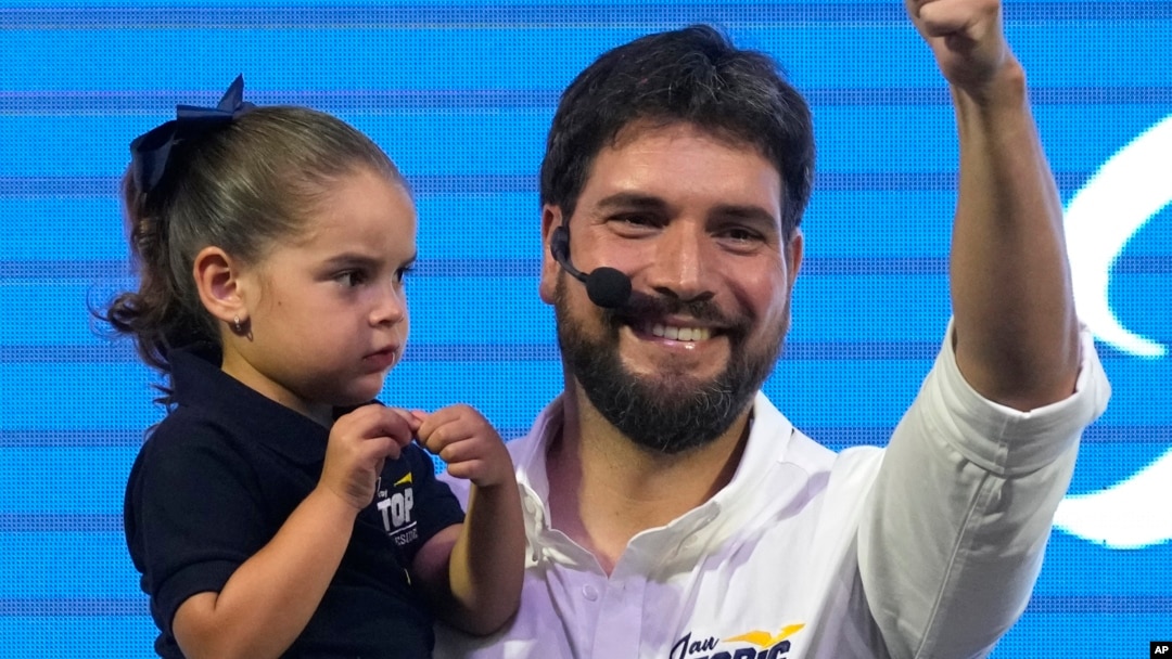 Jan Topic, candidato presidencial, sostiene a su hija mientras sonríe durante un evento el 20 de agosto, en Guayaquil, Ecuador. AP