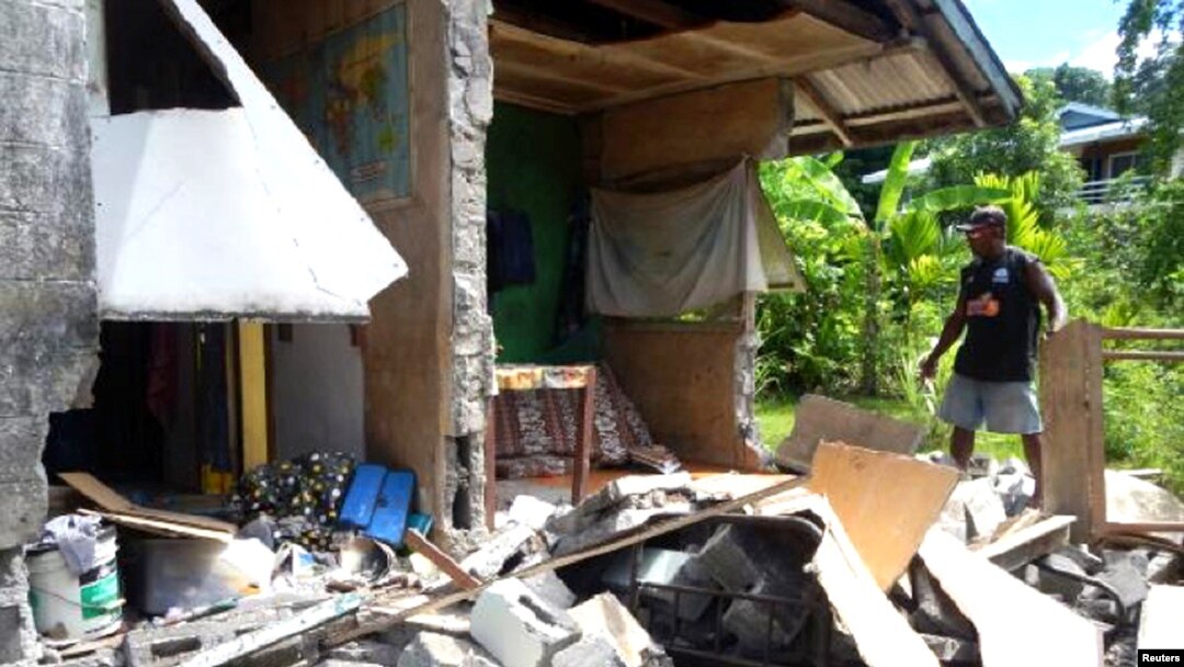 A man stands alongside a building belonging to the World Vision aid organization that was damaged by an earthquake in Kirakira on the Solomon Islands, Dec. 9, 2016.