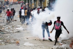 FILE - People clash with security forces during a protest to demand the resignation of Haitian President Jovenel Moise, in Port-au-Prince, Haiti, Sept. 30, 2019.