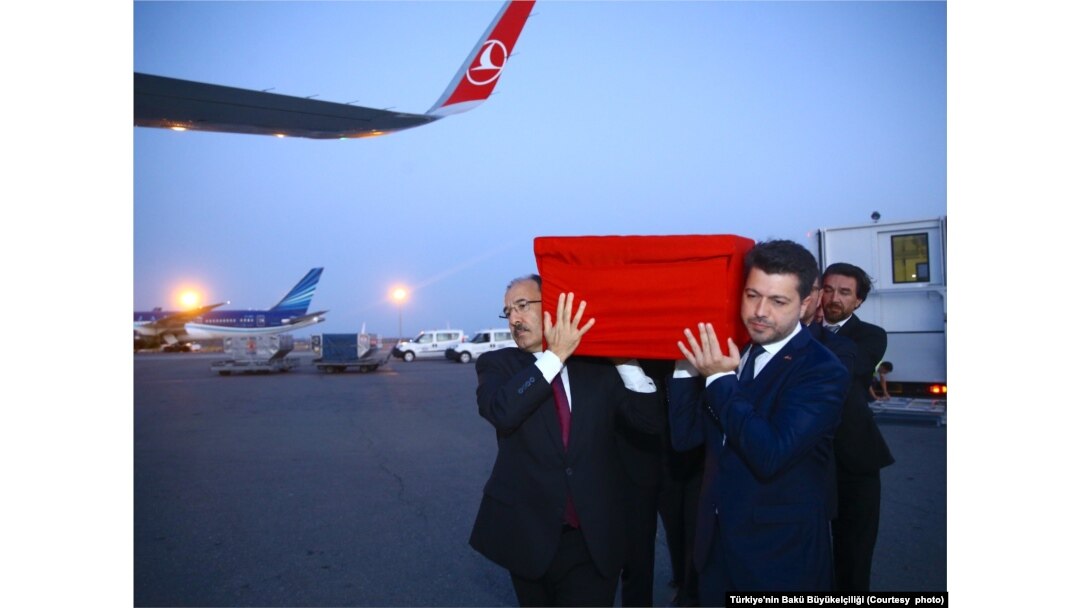 Türkiye'nin Bakü Büyükelçisi Cahit Bağcı (solda), Ayşenur Eygi'nin naaşını İstanbul'a gidecek uçağa taşırken.
