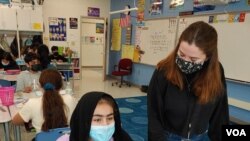 La maestra sustituta Sophie Carter ayuda a un estudiante en la escuela primaria McNair Upper, en Herndon, condado de Fairfax, Virginia. (Deborah Block/VOA)