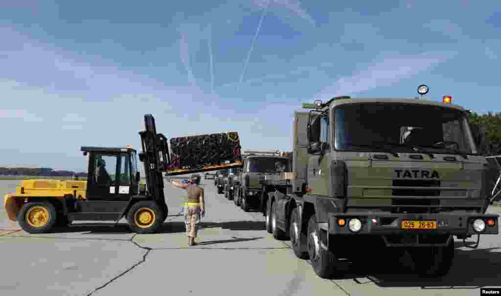 Czech and Canadian soldiers transport boxes of ammunition to be loaded into a plane at Pardubice Airport, in Pardubice, Czech Republic, Sept. 18, 2014.