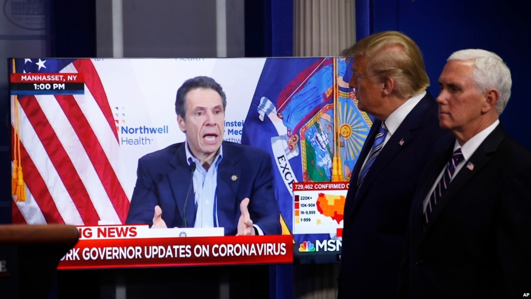 Vice President Mike Pence, right, and President Donald Trump watch a video of New York Gov. Andrew Cuomo speaking during a coronavirus task force briefing at the White House, Sunday, April 19, 2020, in Washington. 
