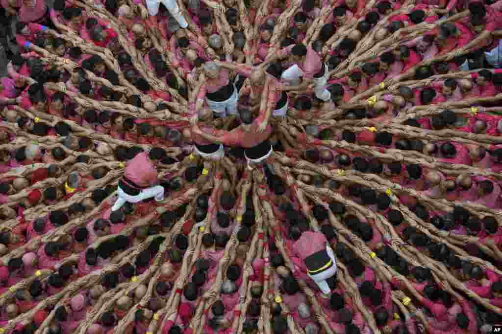 Members of the "Colla Vella dels Xiquests de Valls" try to complete their human tower during the 27th Human Tower Competition in Tarragona, Spain.