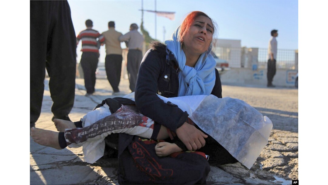 A woman mourns as she holds the body of her daughter, who died in an earthquake, in Sarpol-e-Zahab, western Iran, Nov. 13, 2017.