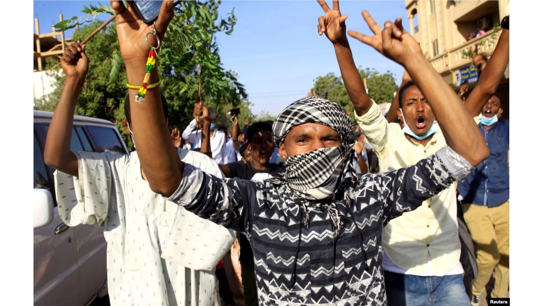 FILE - Demonstrators chant slogans as they march along the street during anti-government protests in Khartoum, Sudan, Dec. 25, 2018.