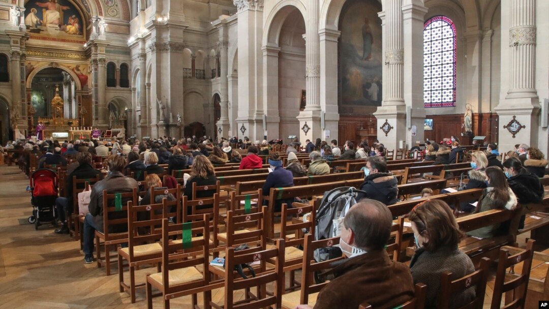Church-goers wearing face masks attend a church service at Saint-Francois-Xavier church in Paris, France, Nov. 29, 2020.