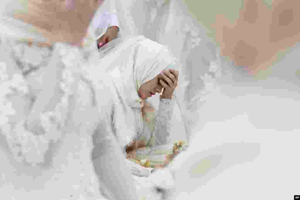 A bride takes part in the simultaneous celebration of 200 weddings to mark the 200th birthday of the city in Grozny, Russia.