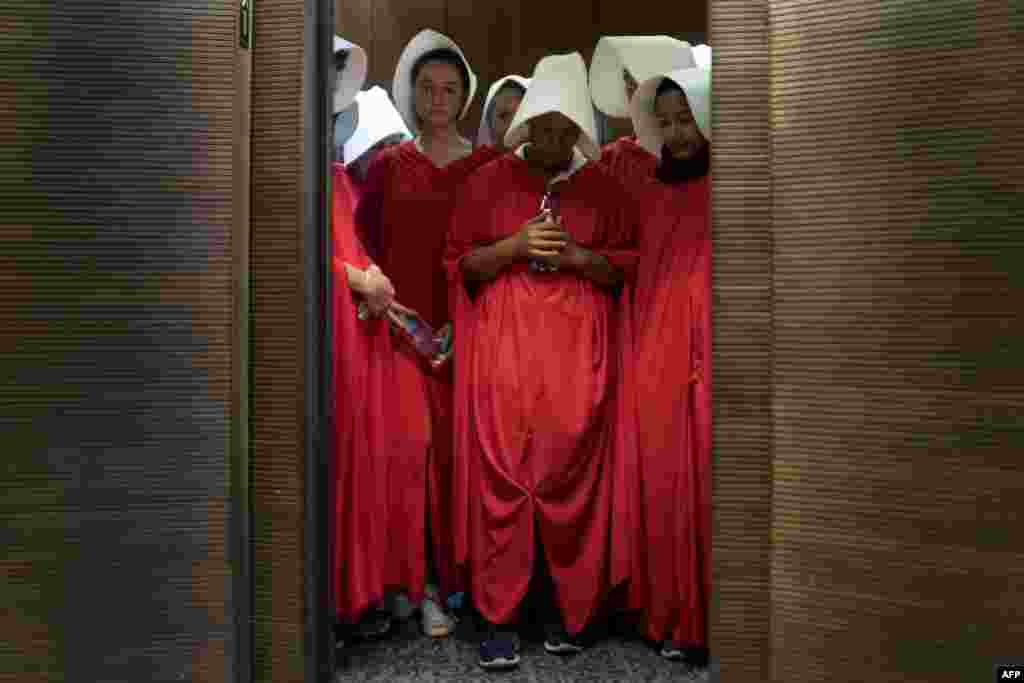 Women dressed as characters from the novel-turned-TV series "The Handmaid's Tale" stand in an elevator at the Hart Senate Office Building as Supreme Court nominee Brett Kavanaugh starts the first day of his confirmation hearing in front of the U.S. Senate on Capitol Hill in Washington, D.C.