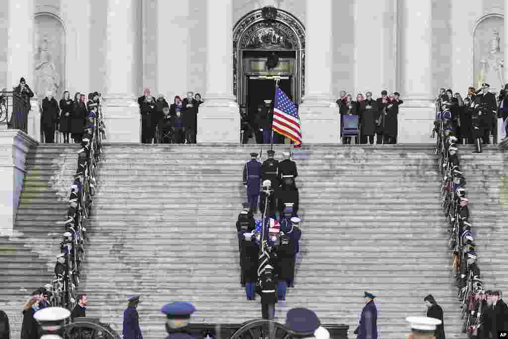 Members of the Carter family look on as a joint services military body bearer team carries the flag-draped casket of former President Jimmy Carter up the steps into the U.S Capitol, in Washington, Jan. 7, 2025.