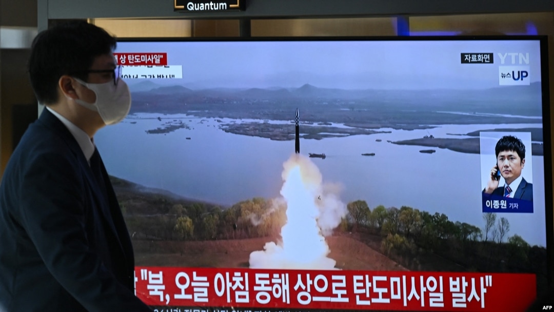A man walks past a television screen showing a news broadcast with file footage of a North Korean missile test, at a train station in Seoul on October 31, 2024.