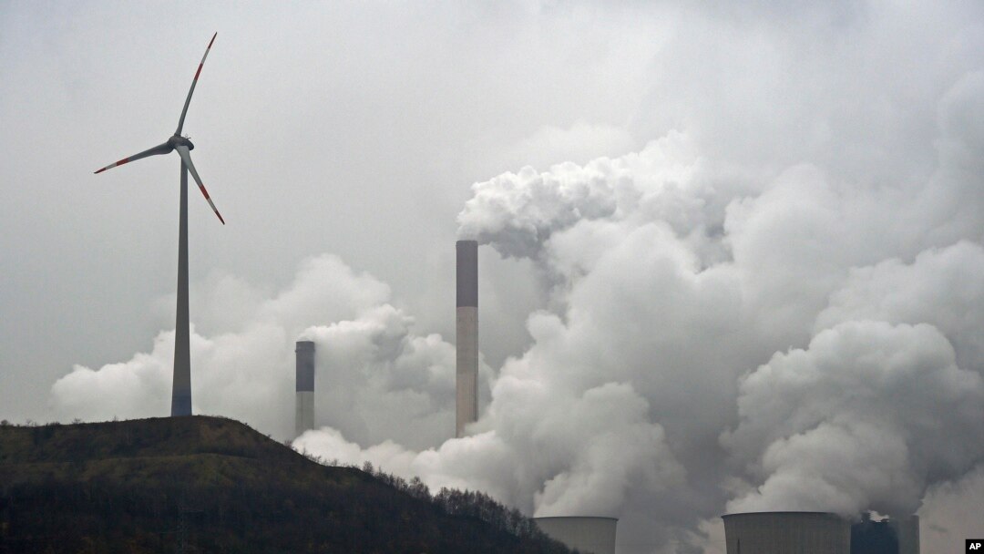 FILE - A wind turbine overlooks the coal-fired power station in Gelsenkirchen, Germany, Dec. 1 2014. 