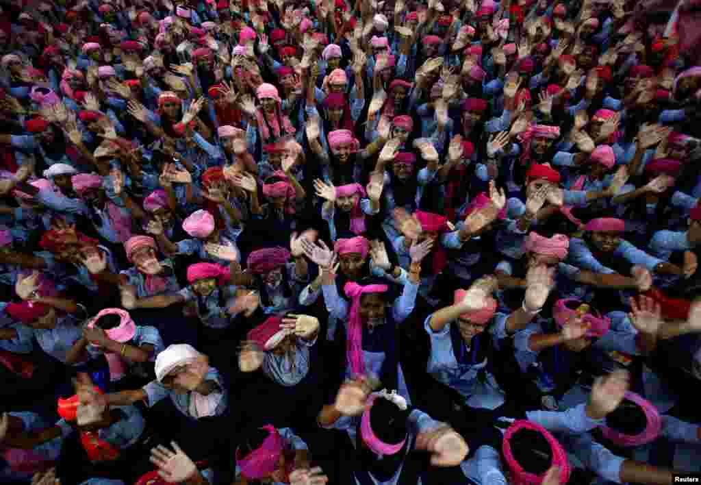 School girls wearing pink turban wave during celebrations to mark International Day of the Girl Child 2018, at a school in Chandigarh, India.