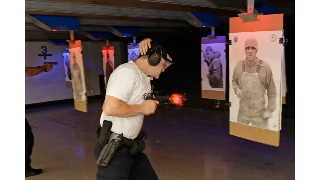FILE: An officer at Washington state's Law Enforcement Academy fires his weapon as a photo of man not holding a weapon moves into view during a training class in Burien, Wash. July 16, 2019.