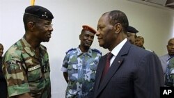 Ivory Coast's President Alassane Ouattara (R) shakes hands with General Philippe Mangou, chief of staff of former pro-Laurent Gbagbo Defense and Security Forces (FDS), at the Hotel du Golf in Abidjan, April 12, 2011