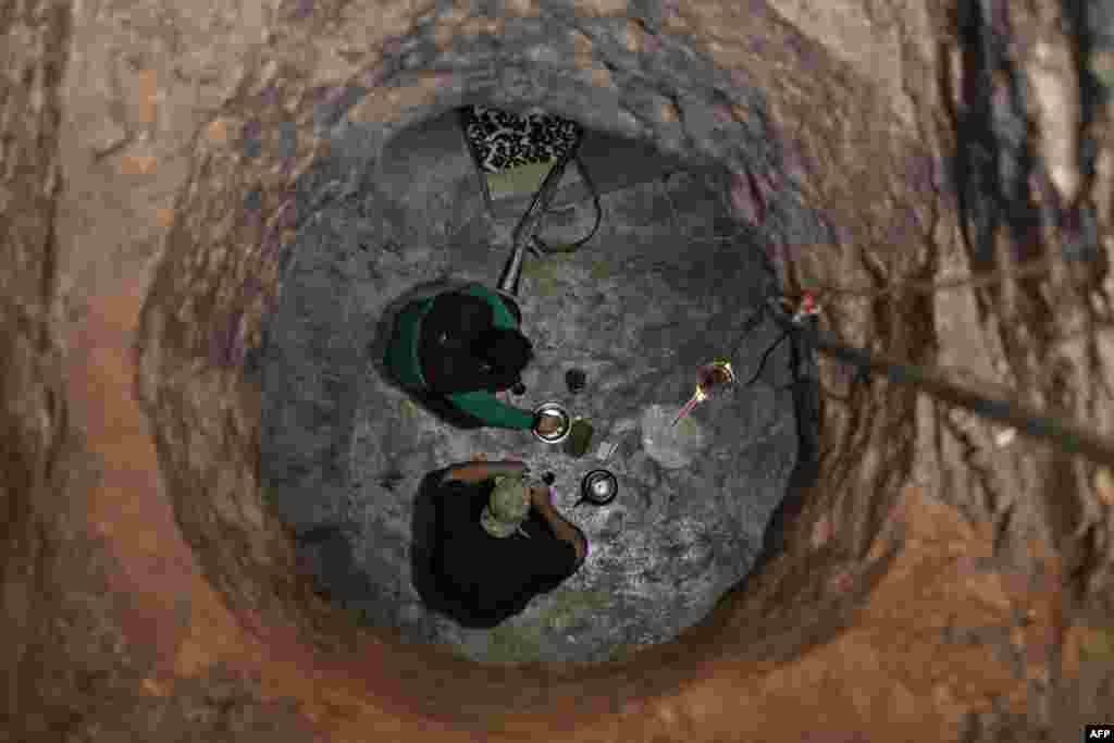 Syrian rebel-fighters with the National Liberation Front (NLF) are seen through a hole siting in a covered structure in the northwestern countryside of Aleppo province, Oct. 9, 2018.