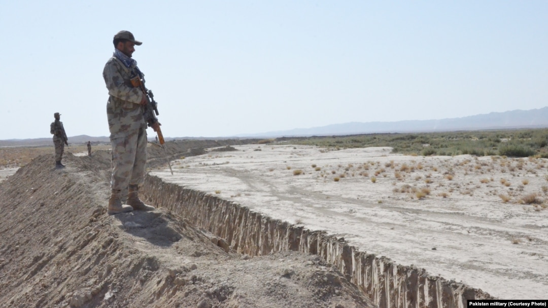Pakistani soldiers stand guard near the trench near the Afghanistan border.