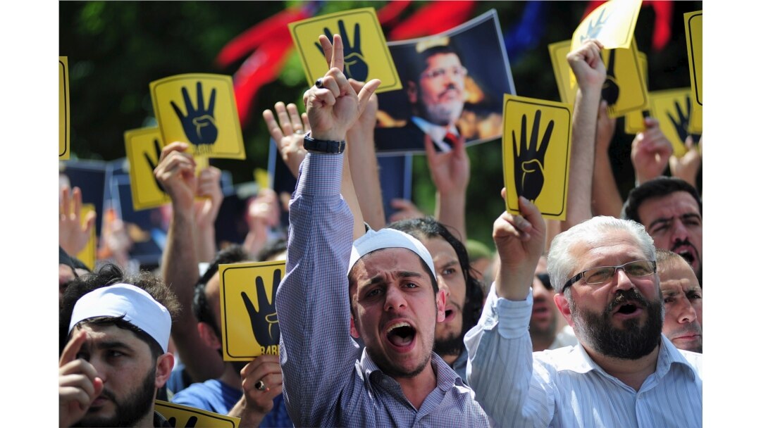 FILE - Pro-Islamist demonstrators shout slogans in favor of former Egyptian President Mohamed Morsi and hold signs that show the Rabaa hand gesture, which symbolizes support for the Muslim Brotherhood, during a rally Istanbul, Turkey, May 24, 2015.