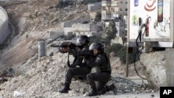 FILE - Israeli border policemen aim their weapons during clashes with Palestinian students in Abu Dis,West Bank, Nov. 2, 2015.