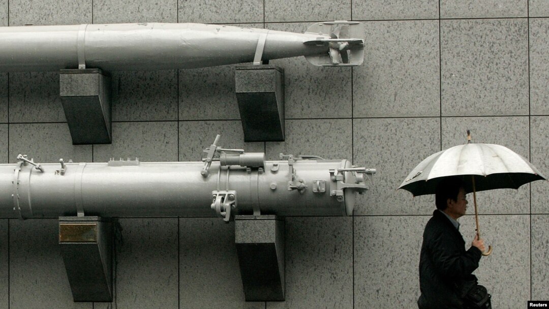 FILE - A man holding an umbrella walks past a torpedo on display outside the Taiwan Armed Forces Museum in Taipei, Jan. 7, 2010. The U.S. State Department has approved a potential arms sale to Taiwan.