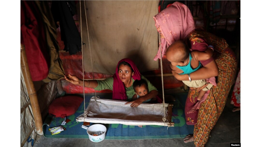 Rohingya refugee women arrange a cradle for child in their makeshift tent in the Balukhali refugee camp in Cox's Bazar, Bangladesh, Aug. 23, 2018.
