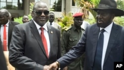 South Sudan's First Vice President Riek Machar, left, and President Salva Kiir, right, shake hands following the first meeting of a new transitional coalition government, in the capital Juba, April 29, 2016. 