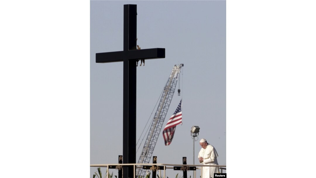 Pope Francis stands next to a wooden cross at the border between Mexico and the U.S. in Ciudad Juarez, Mexico, Feb. 17, 2016.