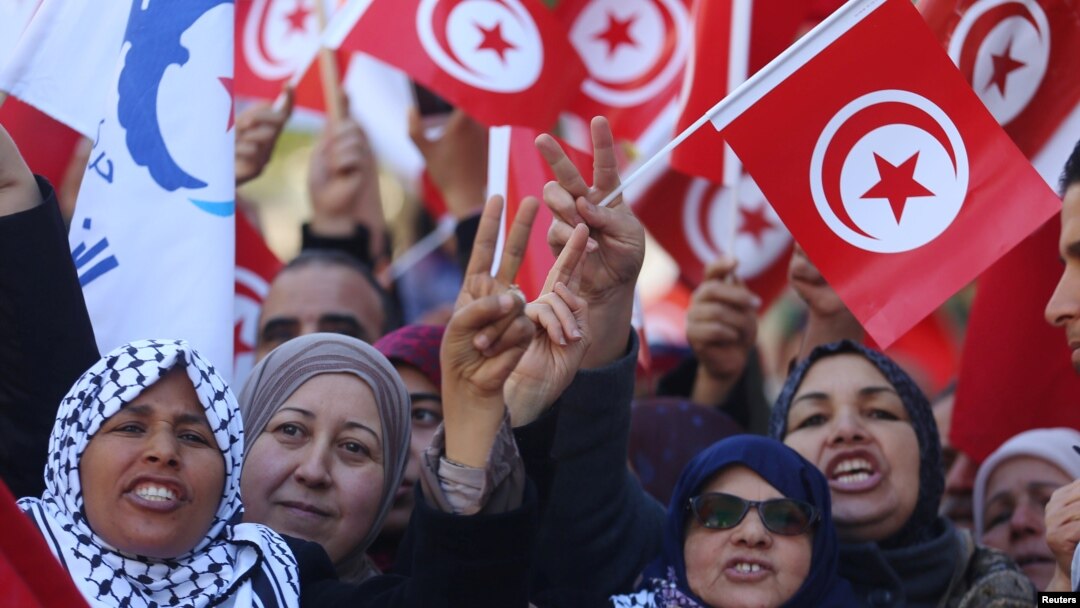People wave national flags during demonstrations on the seventh anniversary of the toppling of president Zine El-Abidine Ben Ali, in Tunis, Jan. 14, 2018.
