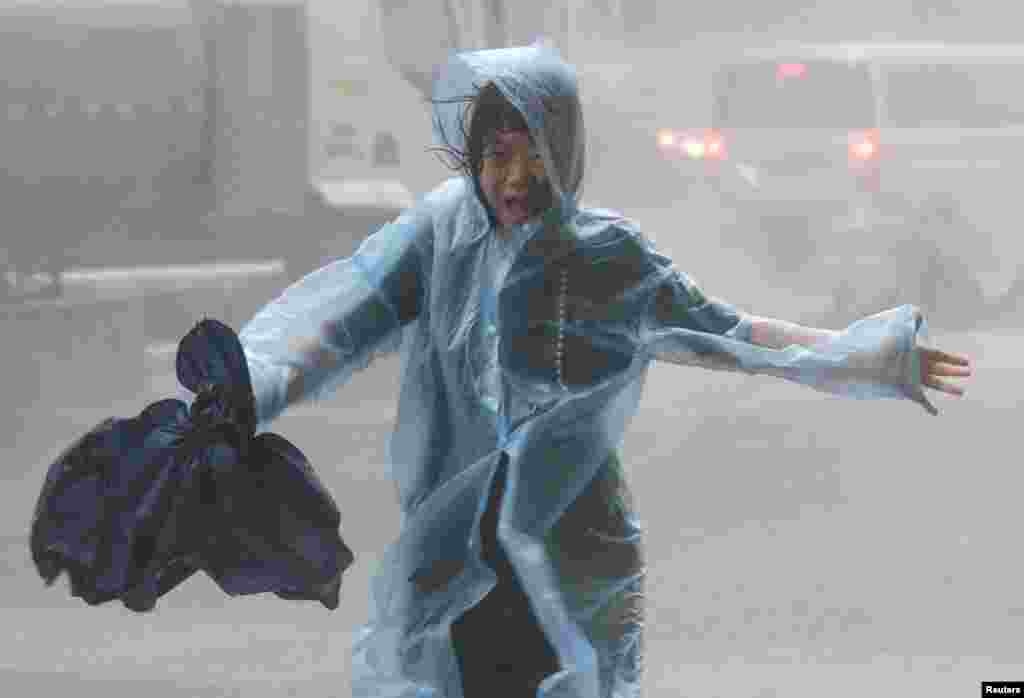 A woman runs in the rainstorm as Typhoon Mangkhut approaches, in Shenzhen, China.