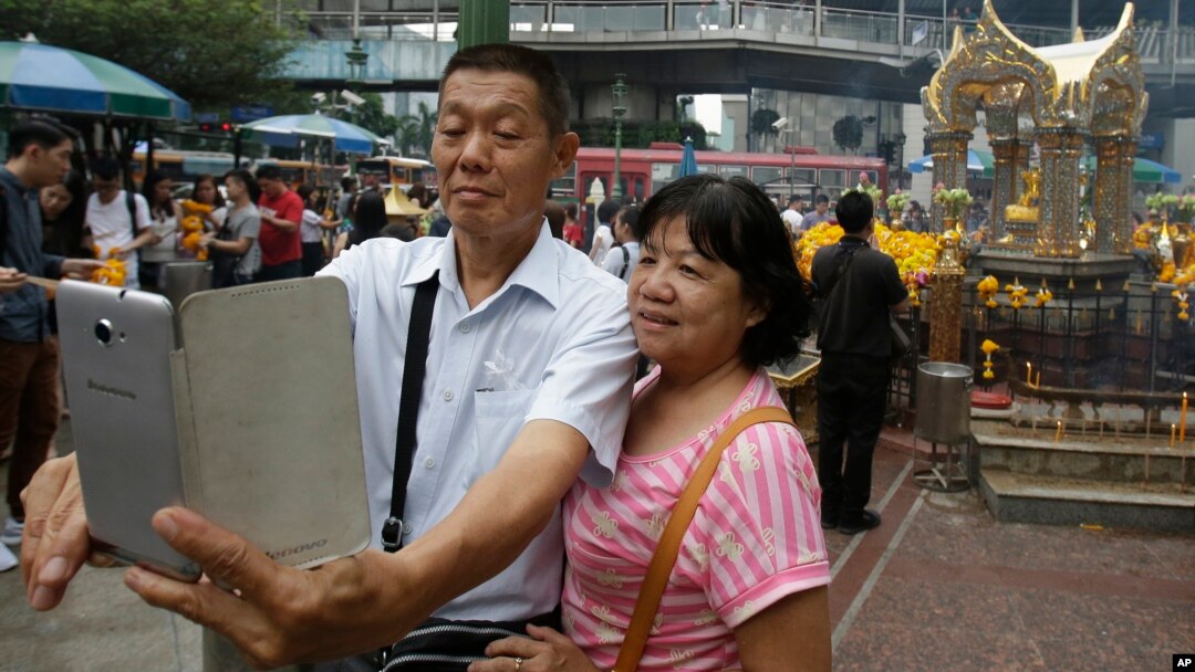 Asian tourists takes a "selfie" in front of the Erawan Shrine in Bangkok, Thailand, Oct. 22, 2015.