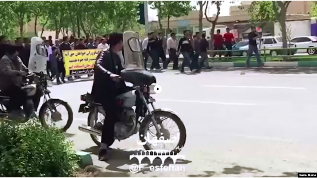 FILE - In this frame from a social media video posted April 13, 2018, people in Khorasgan, Iran, march to protest water shortages that are hurting local farmers.