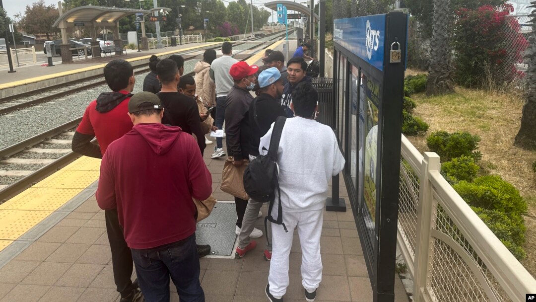 ARCHIVO: Migrantes liberados con citas para presentarse ante una corte de inmigración esperan por un tren en el Aeropuerto Internacional de San Diego, California, EEUU, el 6 de junio de 2024.