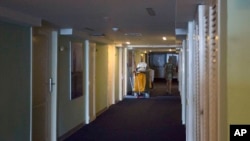 In this Sept. 12, 2017, photo, a person walks past a cleaning cart at the Hotel Capri in Havana, Cuba. Details about a string of mysterious “health attacks” on U.S. diplomats in Cuba indicate the incidents were narrowly confined within specific rooms or parts of rooms. Aside from their homes, officials said Americans were attacked in at least one hotel, the recently renovated Hotel Capri.