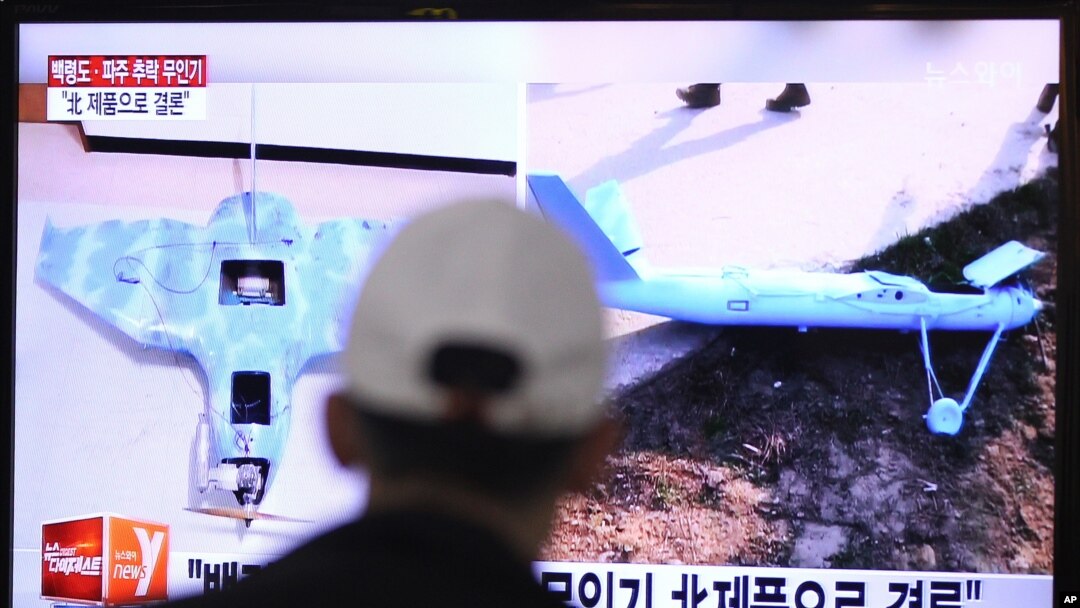 FILE - A man watches a TV news program showing unmanned drones, at the Seoul Railway Station in Seoul, South Korea, Wednesday, April 2, 2014