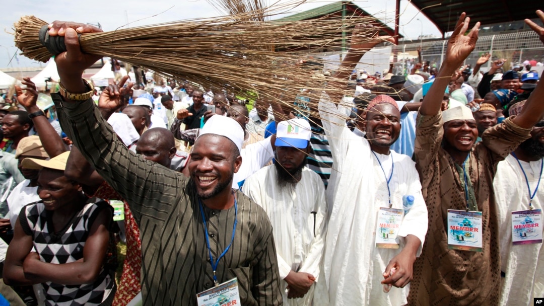 Members of All Progressives Congress party waves brooms the symbol of the party as former military ruler and Presidential aspirant Muhammadu Buhari, delivered a speech during the party convention in Lagos, April 18, 2013.