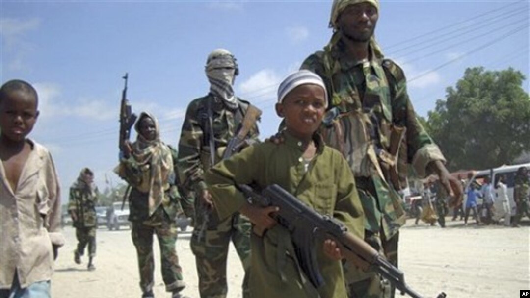 A young boy leads the hard-line Islamist Al Shabab fighters as they conduct military exercise in northern Mogadishu's Suqaholaha neighborhood, Somalia (File Photo)