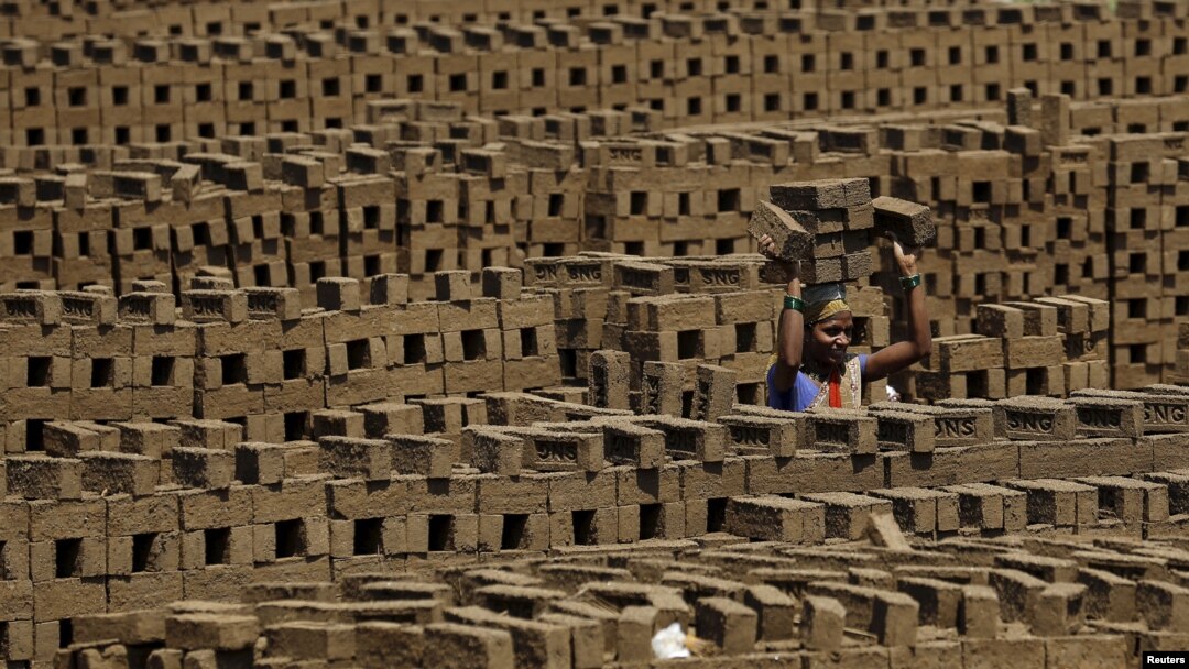 A laborer carries bricks at a kiln in Karjat, India, March 10, 2016. Thousands of brick kiln workers in India's western Maharashtra state are learning from activists that they have the right to a minimum wage, basic amenities and fair treatment - but rema
