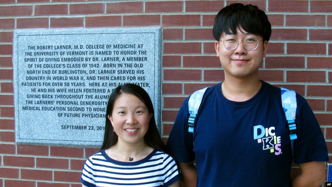Chinese graduate students Zhaojin Li, left, and Pengfei Liu, pose in front of the entrance to the Robert Larner College of Medicine at the University of Vermont in Burlington, Vermont, Aug. 16, 2019.