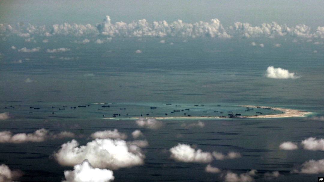 FILE - This aerial photo taken through a glass window of a military plane shows China's alleged on-going reclamation of Mischief Reef in the Spratly Islands in the South China Sea. China rejected a protest from Vietnam on Jan. 3, 2016, over a flight test it has conducted on a new airstrip on a man-made island in the South China Sea, saying it is part of China's territory.