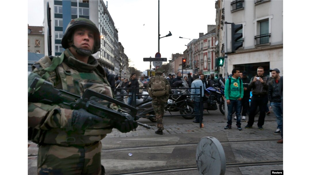 French soldiers secure the area as shots are exchanged in Saint-Denis, France, near Paris, Nov. 18, 2015, during an operation to catch fugitives from Friday night's deadly attacks in the French capital.