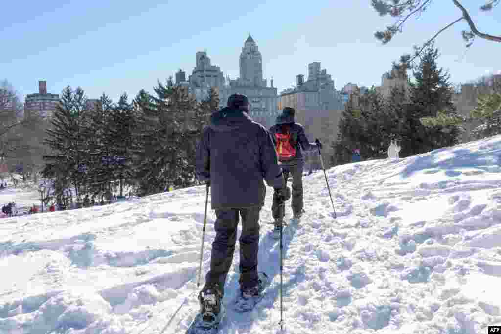 Two men walk with snowshoes through New York’s Central Park, Jan. 24, 2016.