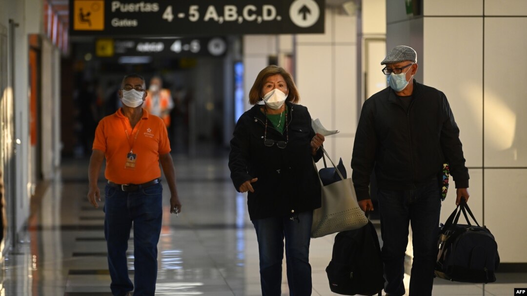 Los pasajeros en el Aeropuerto Internacional San Oscar Romero en San Luis Talpa, El Salvador, usan máscaras faciales como precaución contra la propagación del nuevo coronavirus, COVID-19, el 12 de marzo de 2020. [AFP]