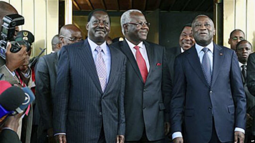 Kenya's Prime Minister Raila Odinga, left, Sierra Leone's President Ernest Bai Koroma, center, and Ivory Coast President Laurent Gbagbo, right, pose for photographers at the presidential palace in Abidjan, Jan 3, 2011