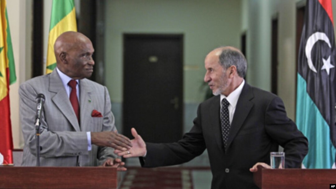Senegal's President Abdoulaye Wade, left, shakes hands with National Transitional Council chairman Mustafa Abdul-Jalil after their joint press conference in Benghazi, Libya, June 9, 2011