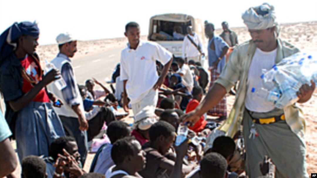 A Yemeni NGO worker distributes water on Somali asylum seekers upon their arrival on the beach of Hasn Beleid village, 230 kms east of the Red Sea port of Aden, (File October 15, 2008).