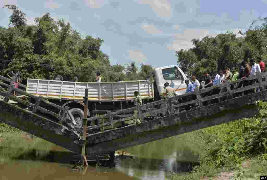 Indian rescue workers and villagers gather near a collapsed bridge in Phasidewa village near the India-Bangladesh border on the outskirts of Siliguri in the Indian state of West Bengal. No casualties were reported in the collapse.