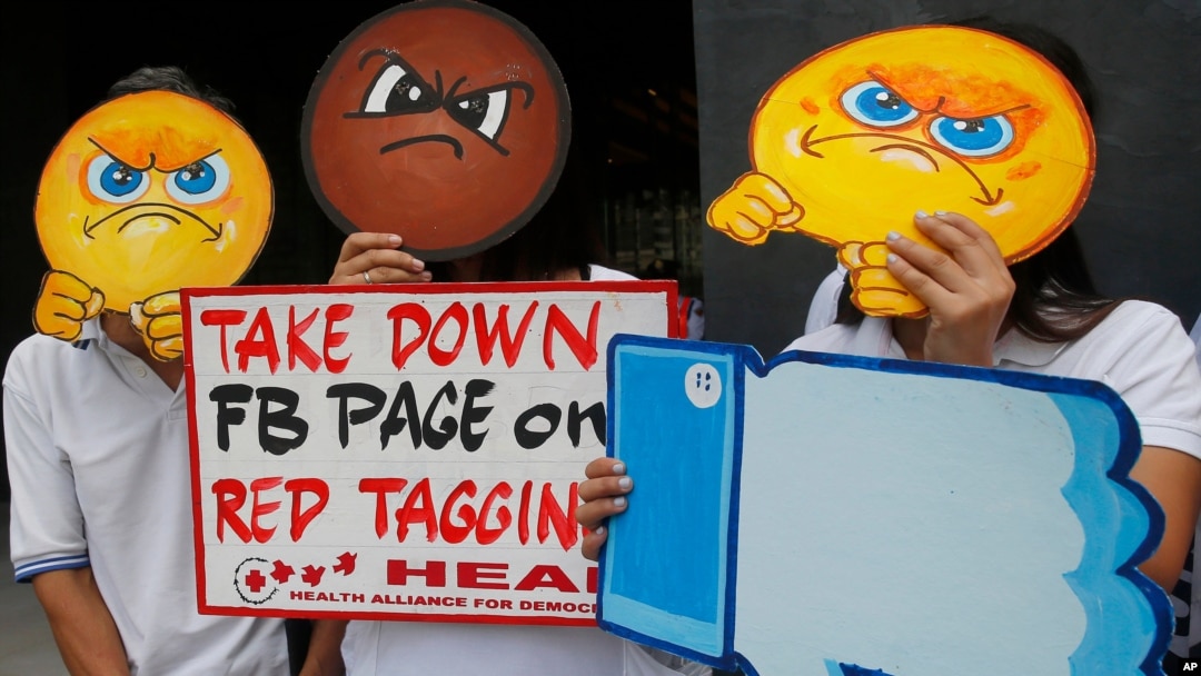 Personas con máscaras protestan en la sede de Facebook en Manila, Filipinas, por la supuesta inacción de la empresa contra las noticias falsas, el discurso de odio y el vilipendio de activistas en Taguig, en el este de Manila, el 9 de mayo de 2019.