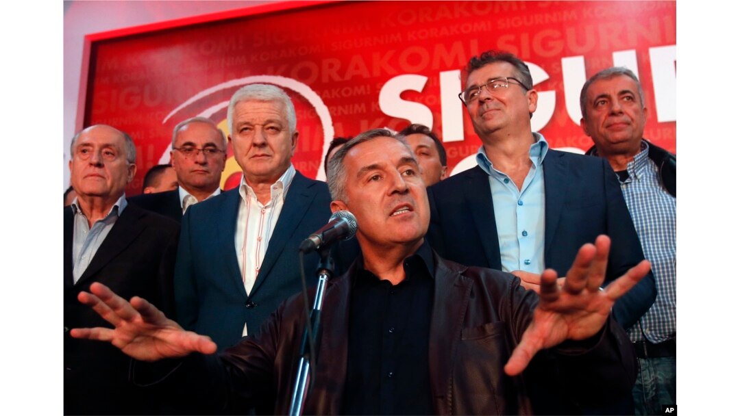 FILE - Milo Djukanovic, center, then the prime minister of Montenegro, speaks in his headquarters in Podgorica, Oct. 17, 2016. Since then, a Montenegrin court has confirmed indictments against 14 people for allegedly masterminding a coup attempt in Montenegro that included an attempt on Djukanovic's life.